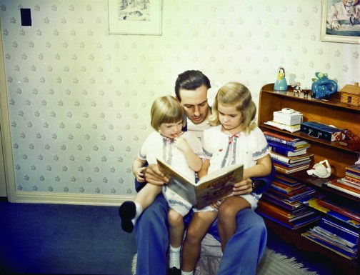 Walt Disney shares a story with his two daughters, Sharon and Diane.